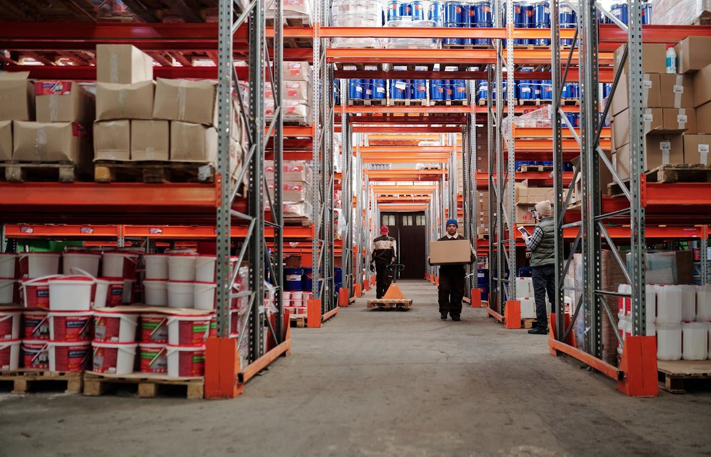 Magazzino ricambi con scaffalature affollate e flusso operatori